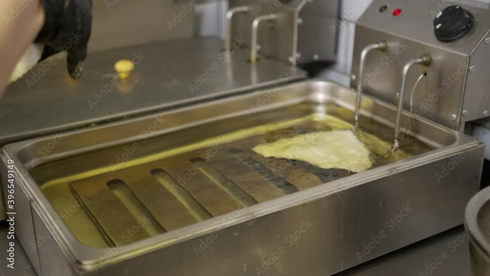 Cooking oil boiling and bubbling in fryer for deep frying dishes in a