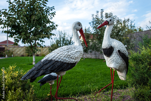 Decorative elements for home garden. Handmade figures of wild crane birds. Two artificial colored statues in the backyard. Landscape design at home. Outdoor decorations for home courtyard or parks.