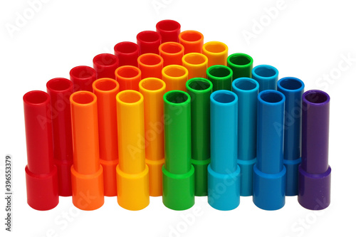 Rainbow colored plastic pipes isolated against white background