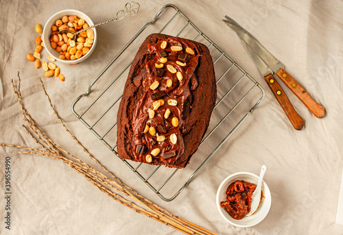 Chocolate Brownies cake with nuts and caramel frosting on wire rack on a light linen cloth. Top view.Christmas baking goods concept