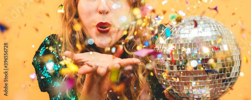 Foto Happy fashion girl blowing confetti holding vintage disco ball - Party concept -
