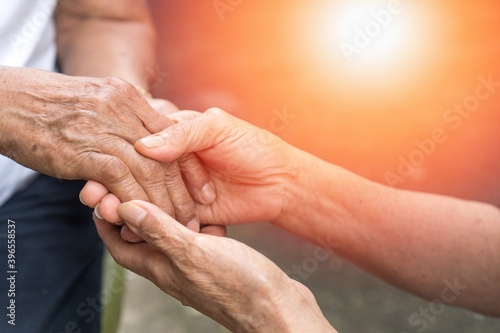 Aging society with Senior hand holding elder together in hospice care background. Philanthropy kindness to disabled old people concept. photo