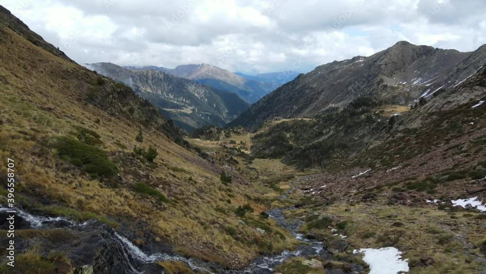 beautiful valley between mountains flown over with drone. many clouds next to a river and a mountain refuge. Mountain in Andorra, the European Pyrenees. 60fps video available for Slowmotion beautiful valley between mountains flown over with drone. many clouds next to a river and a mountain refuge. Mountain in Andorra, the European Pyrenees. 60fps video available for Slowmotion