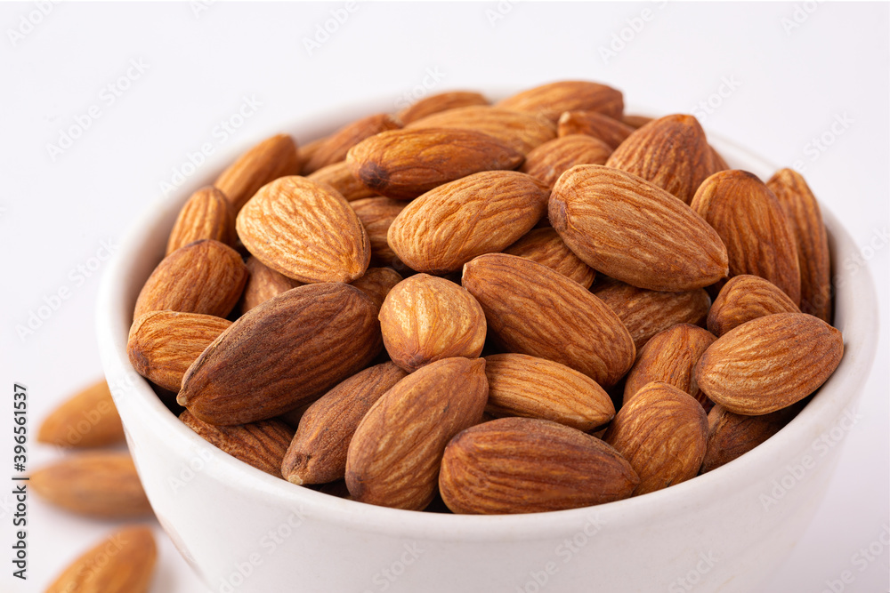 Close-up of fresh raw almonds on a white background Close-up of fresh raw almonds on a white background