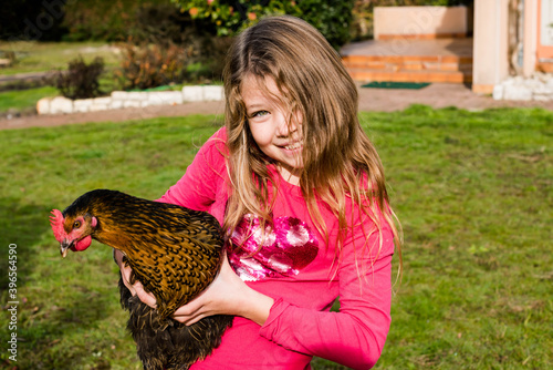 beautiful portrait a young girl holding a hen in her arms
