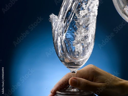 hand holding a glass of pouring water