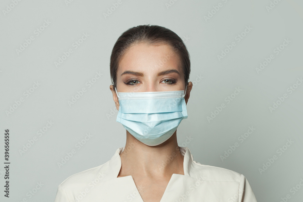 Portrait of woman wearing protective medical face mask on white background. Medicine, cosmetology and vaccination concept Portrait of woman wearing protective medical face mask on white background. Medicine, cosmetology and vaccination concept