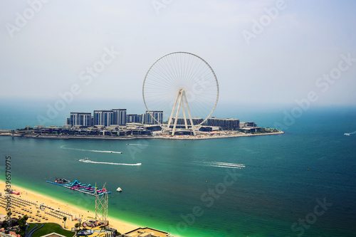Dubai eye, UAE - 08.22.2020: Famous, the biggest ferris wheel at Bluewaters island at sunny summer day with turquiose calm sea and Jumeirah beach view © mynoemy1