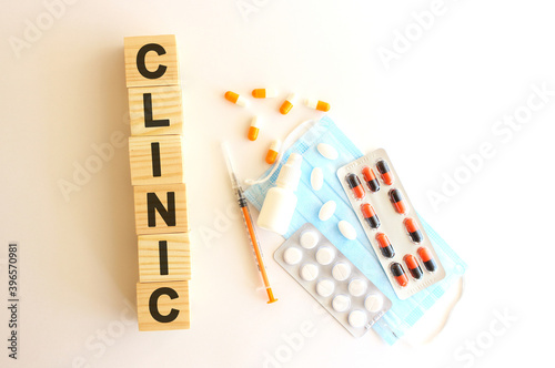The word CLINIC is made of wooden cubes on a white background. Medical concept.