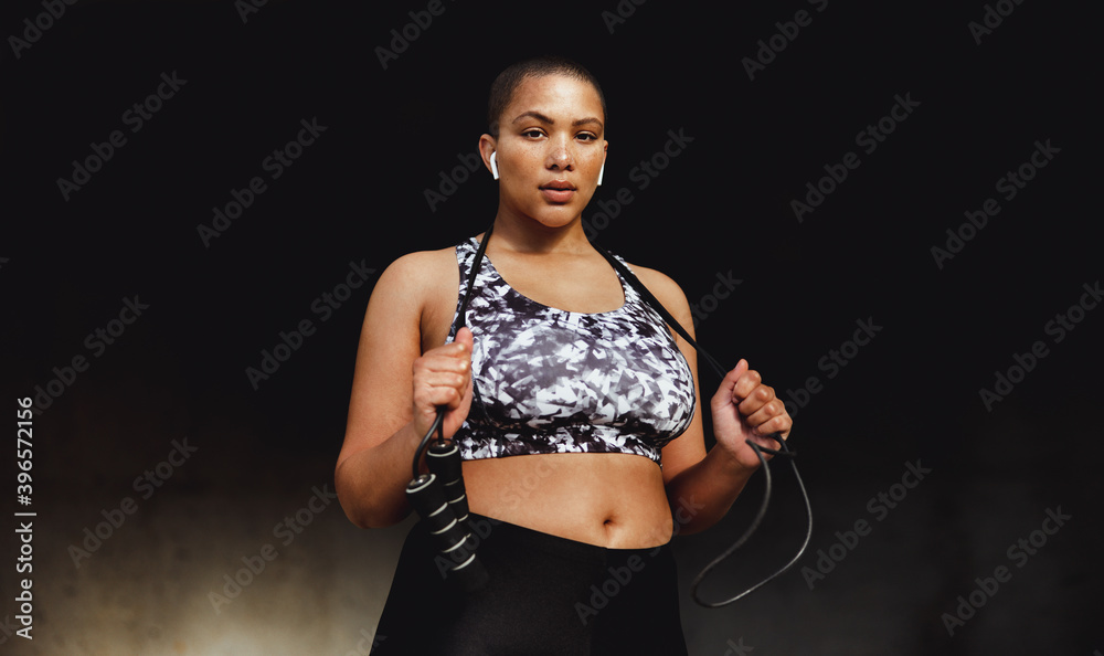 Obraz premium Fitness woman relaxing outdoors holding a skipping rope