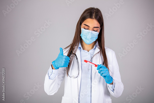 Doctor wearing highly protective suit and examining a novel coronavirus covid 19 test tube. Nurse or doctor with face mask holding blood test with positive result for Coronavirus 2019-nCoV