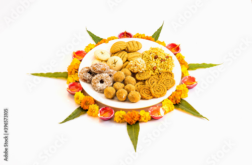 diwali snacks kept on Rangoli design made with flower petals of rose and marigold  for Diwali celebration in India photo