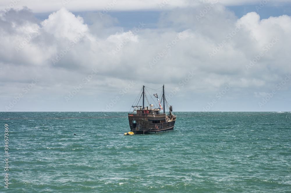 pirate boat on the high seas with clouds in the background pirate boat on the high seas with clouds in the background