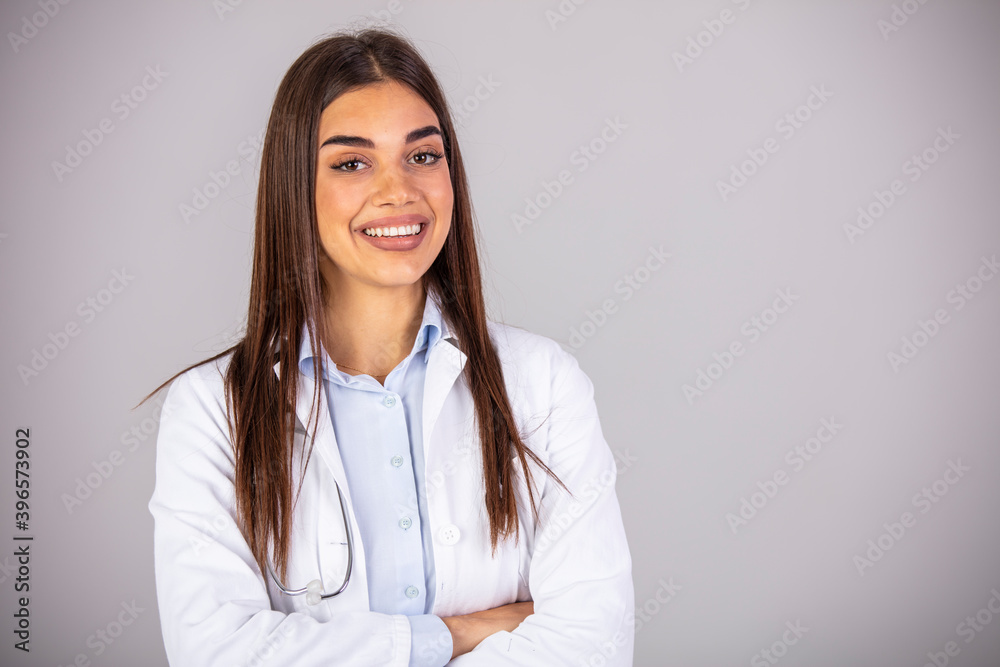 Portrait of confident smiling female doctor. Mid adult medical professional is wearing lab coat and stethoscope. She is standing against gray wall in hospital.
