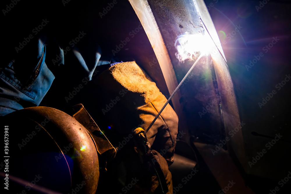 Welder is assembling the workpiece by process shielded metal arc