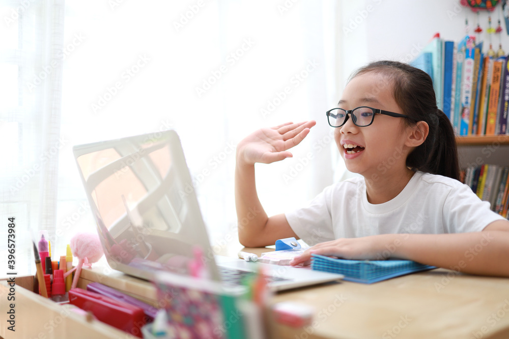 Portrait of 11-year-old teenager Asian girl using laptop for online study during homeschooling at home Portrait of 11-year-old teenager Asian girl using laptop for online study during homeschooling at home