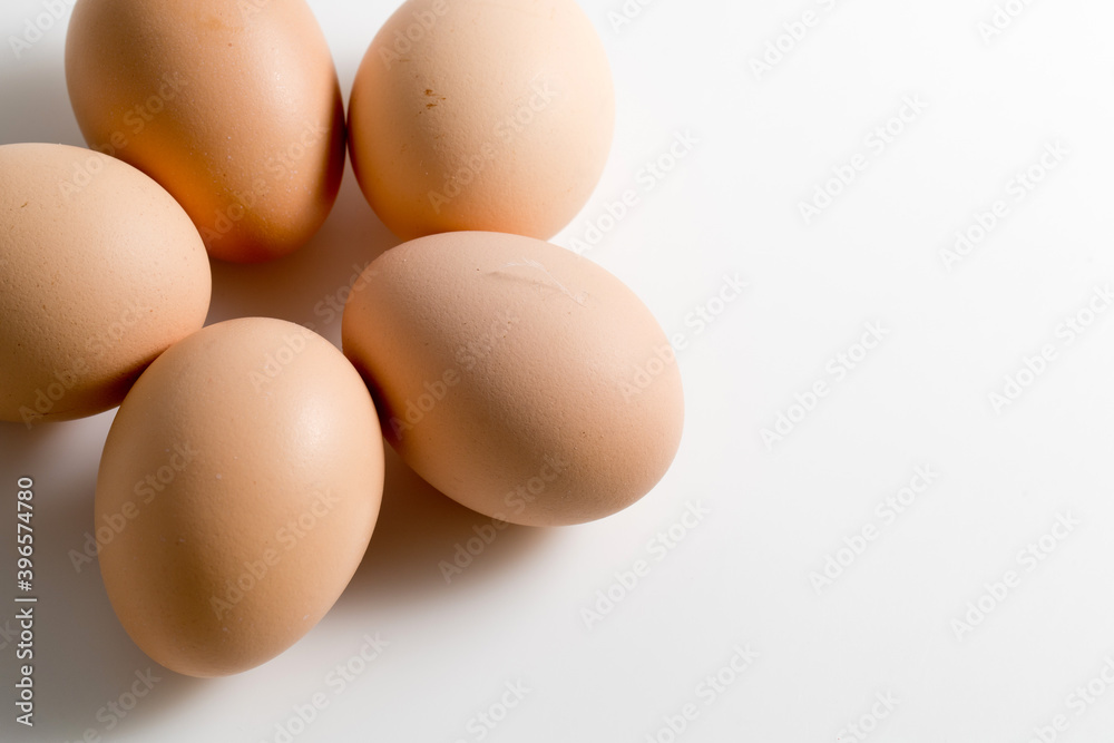 Five brown organic fresh raw eggs. Cut out and isolated on white background with soft shadows for added dimension.