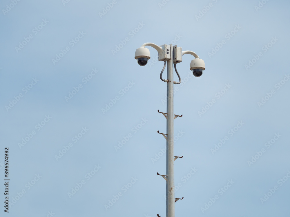 360 Degree fish eye dome CCTV is installed on column against blue sky. 360 Degree fish eye dome CCTV is installed on column against blue sky.