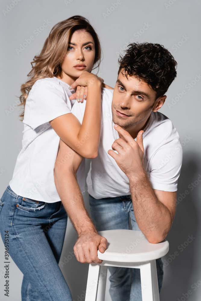 couple in white t-shirts hugging isolated on grey couple in white t-shirts hugging isolated on grey