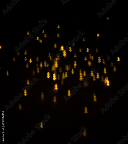 Fototapeta Naklejka Na Ścianę i Meble -  Banner with yellow unfocused lights garlands in form of Christmas tree. Beautiful bright curly bokeh. Magic background for new year and Christmas. Bokeh on black background for use in photo editor.