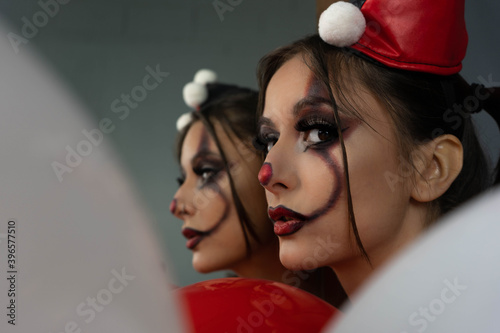 Fun photo session with a young arlekin woman dressed in red, black and white. Nice images for carnival days or for costume and makeup businesses. photo