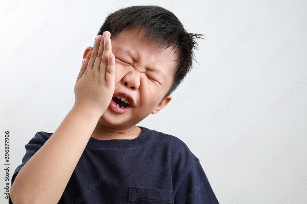 Portrait of a 7yearold Asian boy suffering from a toothache, dental