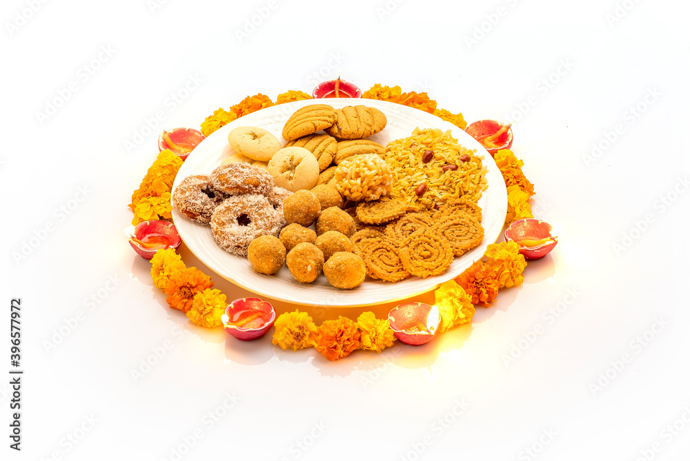 diwali snacks kept on Rangoli design made with flower petals of rose and marigold for Diwali celebration in India diwali snacks kept on Rangoli design made with flower petals of rose and marigold for Diwali celebration in India