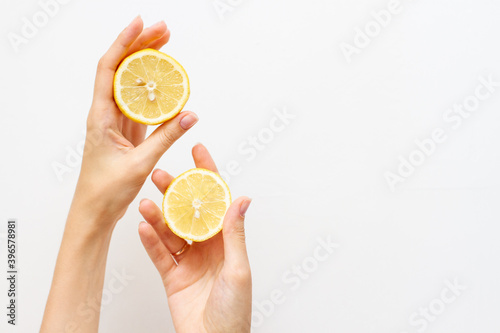 Woman holding half of fresh lemon, free space for text