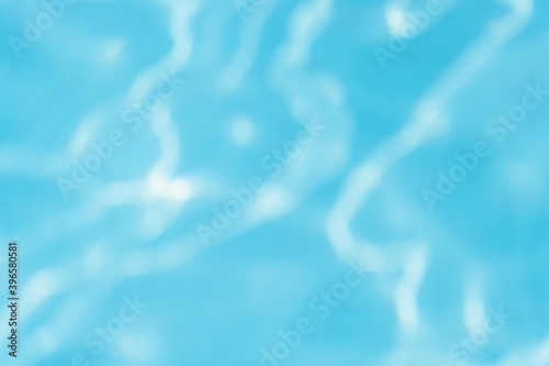 Beautiful abstract gradient photo background. Unfocused sunny rippling blue surface of outdoors swimming pool.