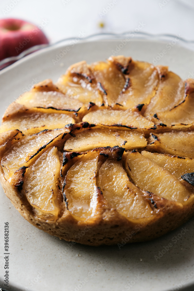 Upside-Down Apple Cake set on white cafe table background. Upside-Down Apple Cake set on white cafe table background.