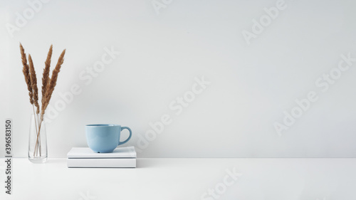The mug stands on a stack of books on a white background. Natural and eco-friendly materials. Copy space, mock up.