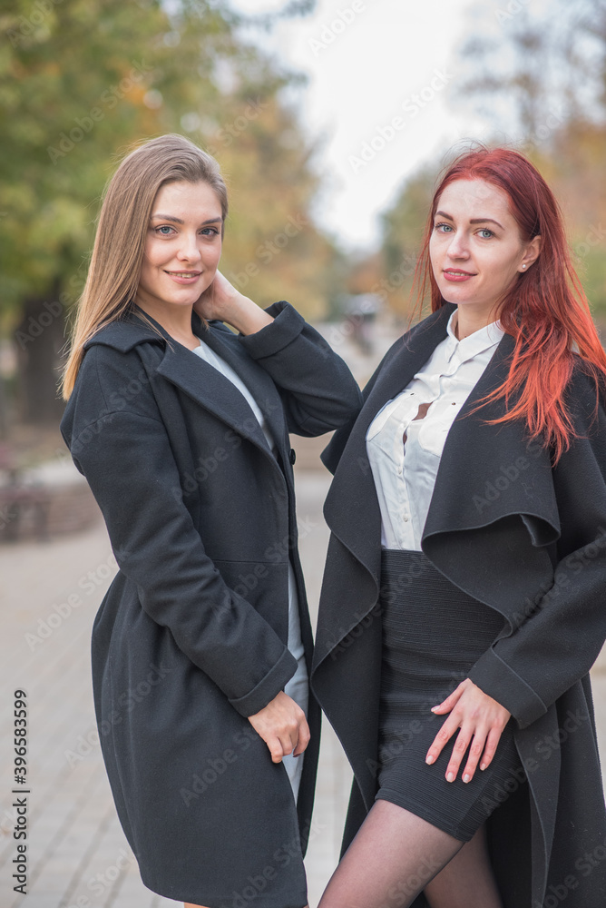 Two cute young girls happily posing on an autumn day Two cute young girls happily posing on an autumn day