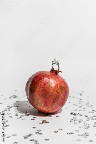 pomegranate on a white background. pearl ring.