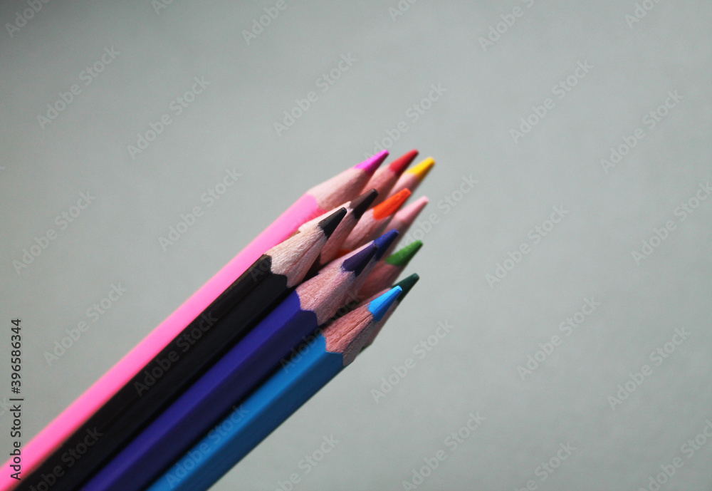 Colored sharpened pencils collected with a pile on a gray background, close-up, top view. Stationery. Creation. Colored sharpened pencils collected with a pile on a gray background, close-up, top view. Stationery. Creation.