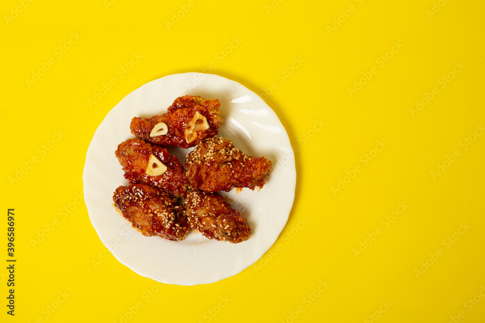 Crispy sesame chicken legs with sticky sweet Asian sauce on a plate Crispy sesame chicken legs with sticky sweet Asian sauce on a plate