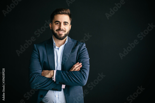 Young man, with jacket and shirt, looking like an entrepreneur, smiling, arms crossed. In a wall of the street background. Work and young entrepreneurs concept