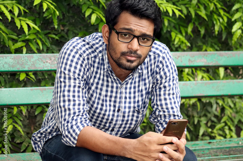 Smart Man Sitting and looking for girlfriend showing Mobile phone © Arun Davidson 