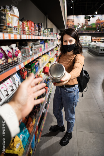 woman giving can with tea at grocery store
