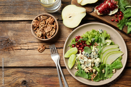 Fresh salad with pear on wooden table, flat lay