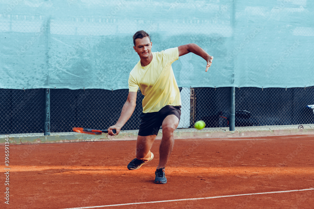 Young handsome man playing tennis on the tennis court Young handsome man playing tennis on the tennis court