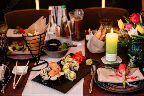 Sushi in a restaurant on a banquet table. Festive table setting with plates, cutlery and snacks. Elegant stylish table setting.