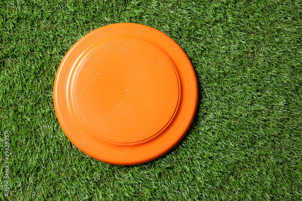 Orange plastic frisbee disk on green grass, top view Stock-Foto | Adobe  Stock