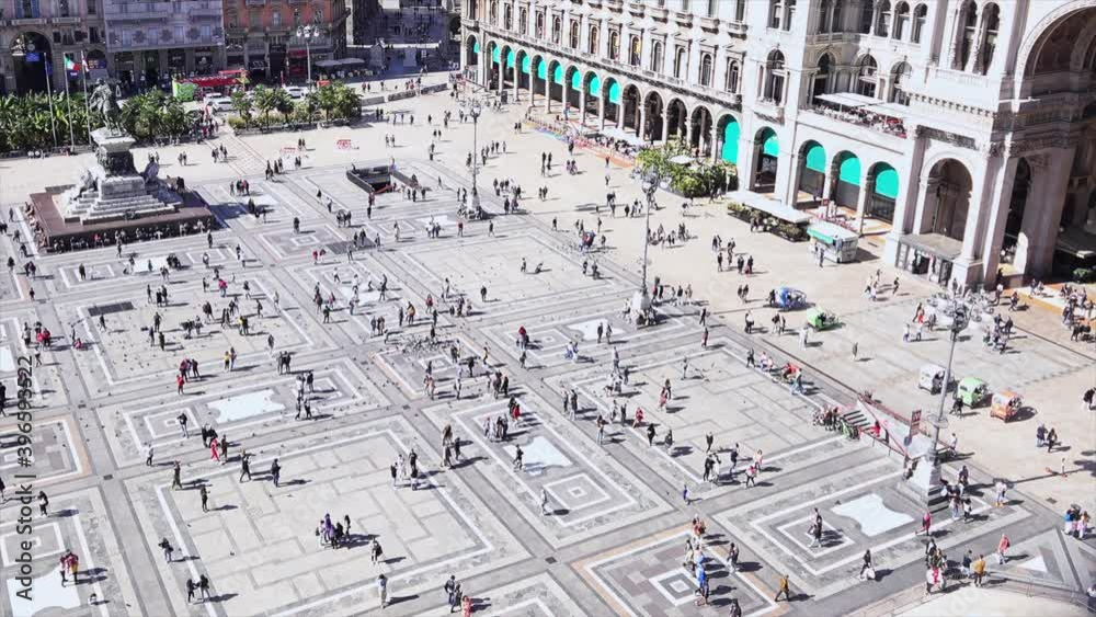 People walk across the Milan Cathedral Square. Piazza del Duomo. Milan, Italy People walk across the Milan Cathedral Square. Piazza del Duomo. Milan, Italy