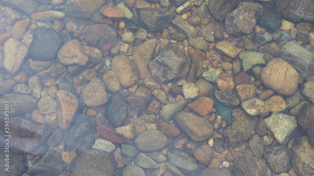 Small and large rocks placed on the ground underwater, close-up view.