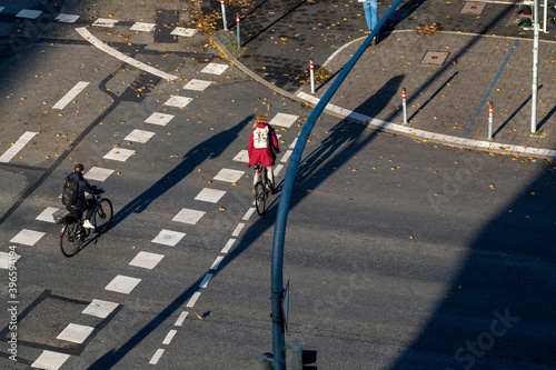 Strassenkreuzung in Deutschland von Oben mit langen Schatten und Fahrradfahrer 