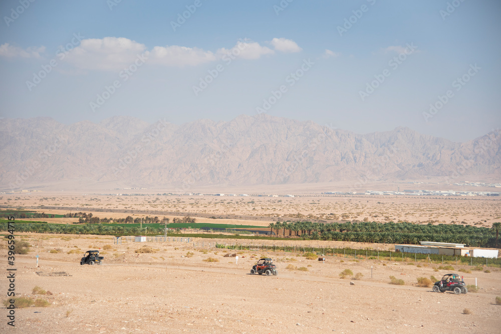 The border between Israel and Jordan against the backdrop of the Aqaba Mountains and the red sea. ATVs in the field. High quality photo