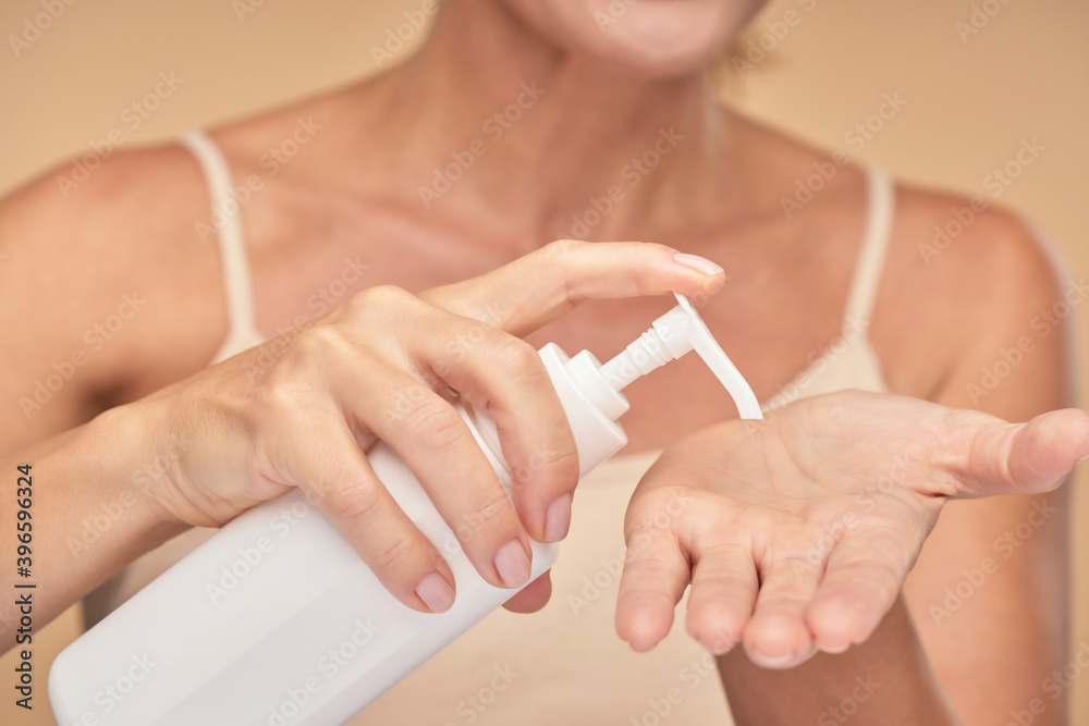 Woman is applying cream on her palm Woman is applying cream on her palm
