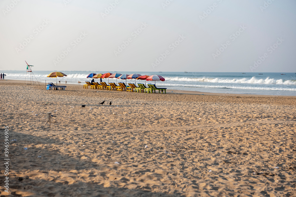 Goa/ India 09 November 2020 Early Morning beach with sun beds and colorful umbrellas on the beach in GOA Goa/ India 09 November 2020 Early Morning beach with sun beds and colorful umbrellas on the beach in GOA