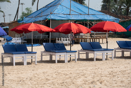 Goa  India 09 November 2020 Row of covered wooden sun beds with colorful umbrellas on the beach in GOA