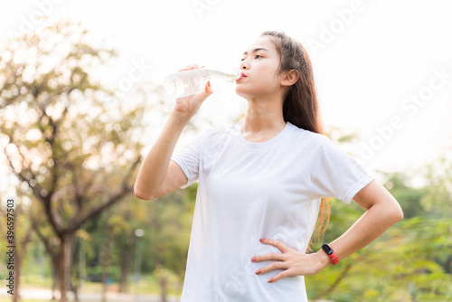 young sport girl drinking fresh water in green garden